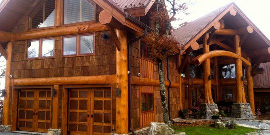 A large wooden house with a tree in front of it.