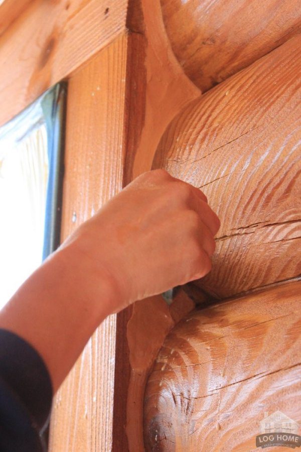 A person is holding onto the wood on their wall.