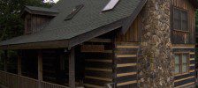 A rustic log cabin with a stone chimney.