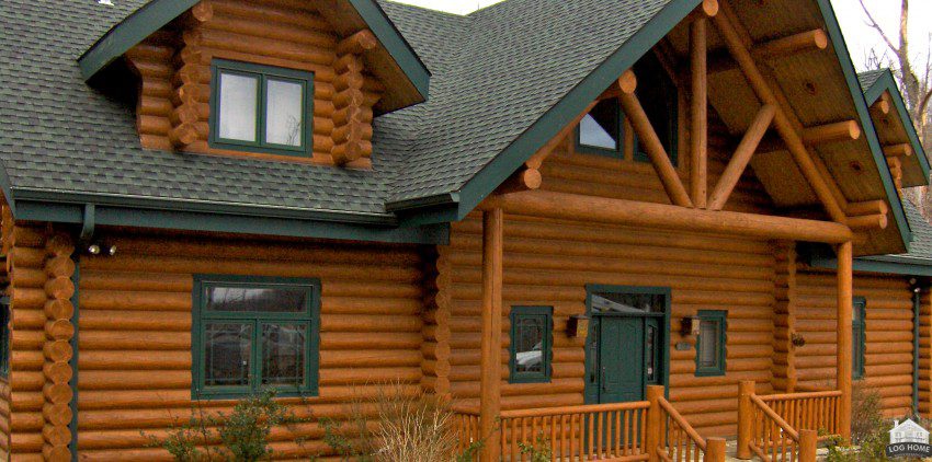 A log home with green trim and wood siding.