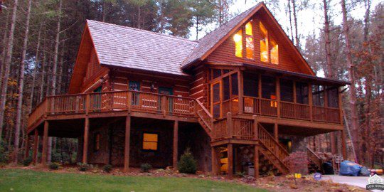 A large wooden house with stairs leading to the front.