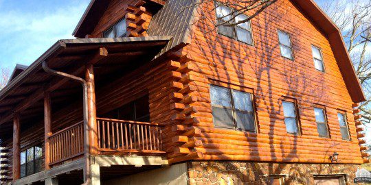 A log cabin with a tree in the background.