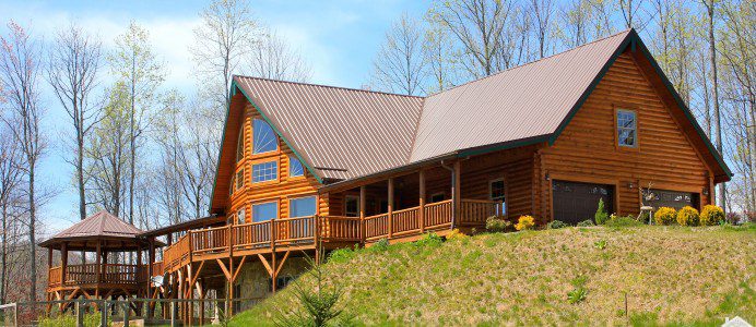 A large log home with a deck and balcony.