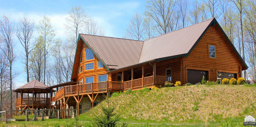 A large log home with a deck and balcony.