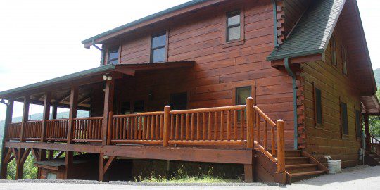 A large wooden house with steps leading to the front.