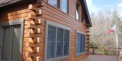 A house with wood siding and windows on the outside.