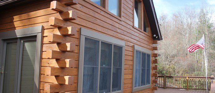 A house with wood siding and windows on the outside.