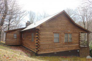 A log cabin with a white roof and windows.