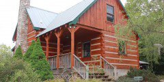 A log cabin with steps leading to the front door.