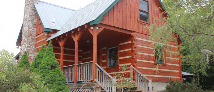 A log cabin with steps leading to the front door.