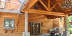 A log home with a porch and bear deck.