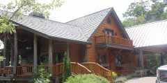 A large wooden house with a porch and stairs.
