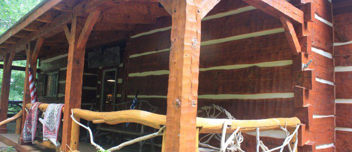 A log cabin with a wooden roof and some logs