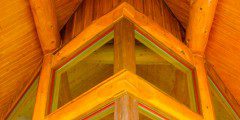 A wooden structure with a window in it, featuring high beams.