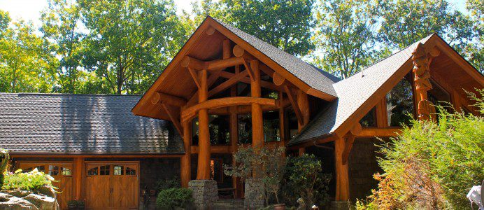 A log home with a large driveway and garage.