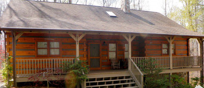 A log cabin with steps leading to the front porch.