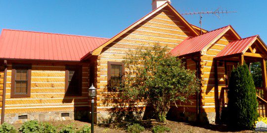 A log cabin with red roof and yellow walls.