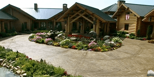 A large house with lots of flowers in the front yard.