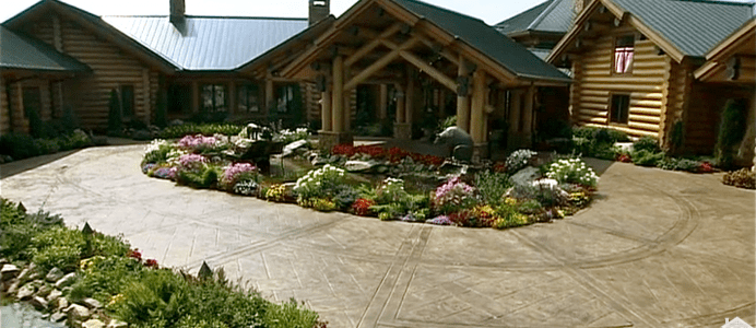 A large house with lots of flowers in the front yard.