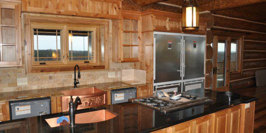 A kitchen with wooden cabinets and black counter tops.