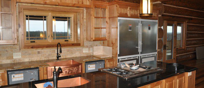 A kitchen with wooden cabinets and black counter tops.